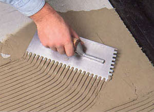 Нанесение раствора при  помощи гребенчатого шпателя