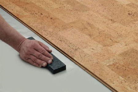 Выравнивание поверхности перед укладкой пробкового покрытия при помощи шкурки